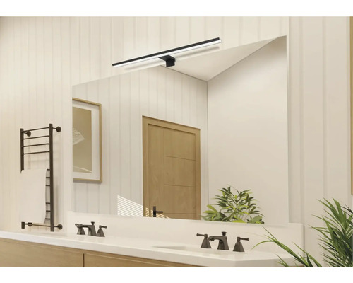 Salle de bains lumineuse avec miroir, lavabo, robinets, sèche-serviettes et éclairage