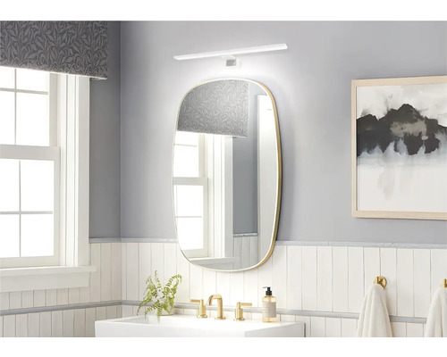 Salle de bains lumineuse avec miroir, lavabo et robinetterie