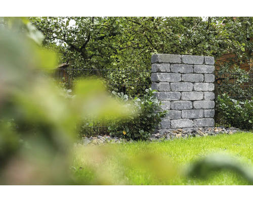 Pilier de jardin maçonné en blocs de pierre à côté d''une pelouse