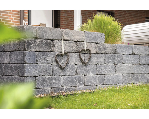 Mur de jardin gris en béton avec deux décorations en forme de cœur