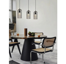 Esszimmer mit Holztisch, Stühlen mit Rohrgeflecht und drei Pendelleuchten mit Käfigdesign