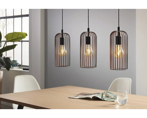 Drei Pendelleuchten mit schwarzem Käfig über einem Holztisch