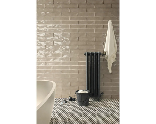 Salle de bains avec mur carrelé, radiateur et sol à motifs