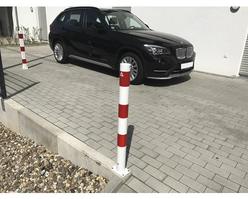 Pfosten zur Absperrung mit einem schwarzen Auto im Hintergrund