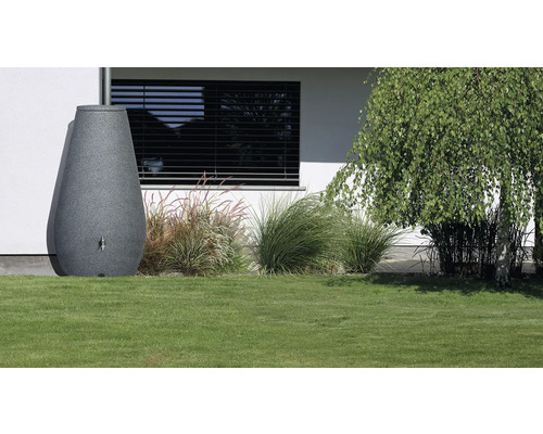 Grauer Regentonne vor einem Haus im Garten