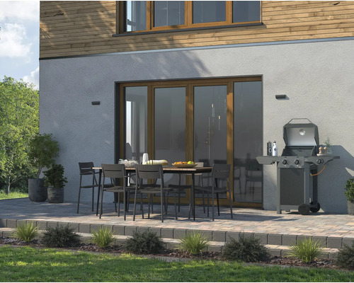 Terrasse avec barbecue, table à manger et chaises devant la maison