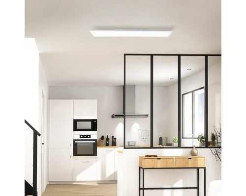 Helle Küche mit Einbauschränken, Mikrowelle, Backofen, Dunstabzugshaube und Deckenleuchte