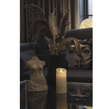 Décoration avec un buste de femme, une bougie et des fleurs séchées sur une table