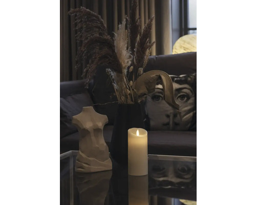 Décoration avec un buste de femme, une bougie et des fleurs séchées sur une table