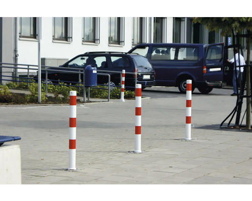 Mehrere rot-weiss gestreifte Leitpfosten auf einem Parkplatz