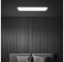 Beleuchtete Zimmerdecke mit LED-Deckenleuchte über Bett