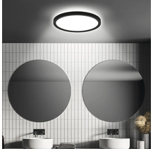 Badezimmer mit runder Deckenleuchte und zwei runden Spiegeln über den Waschbecken