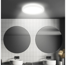 Modernes Badezimmer mit runder Deckenleuchte, Waschbecken und Spiegeln