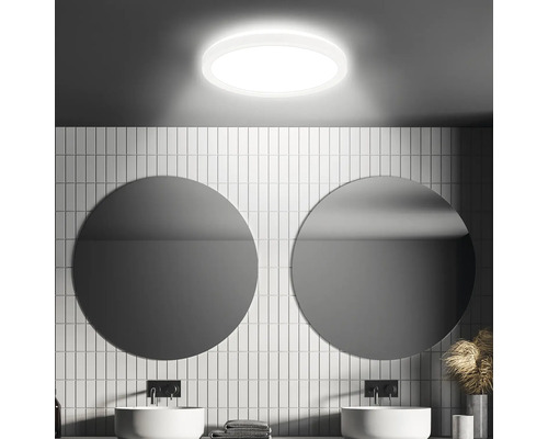 Modernes Badezimmer mit runder Deckenleuchte, Waschbecken und Spiegeln