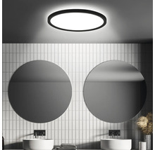 Salle de bain moderne avec miroirs ronds, lavabos et plafonnier rond pour une ambiance lumineuse et élégante.