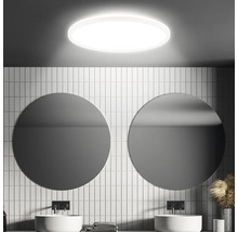 Badezimmer mit runden Spiegeln, weißen Fliesen und runder Deckenleuchte