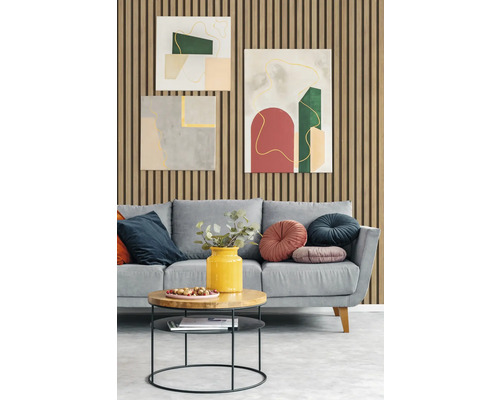 Salon avec un canapé gris, des coussins, une table d''appoint et des peintures murales abstraites devant un mur avec des panneaux en bois