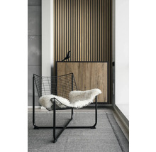 Einrichtungsszene mit modernem Stuhl, Teppich und Holzvertäfelung