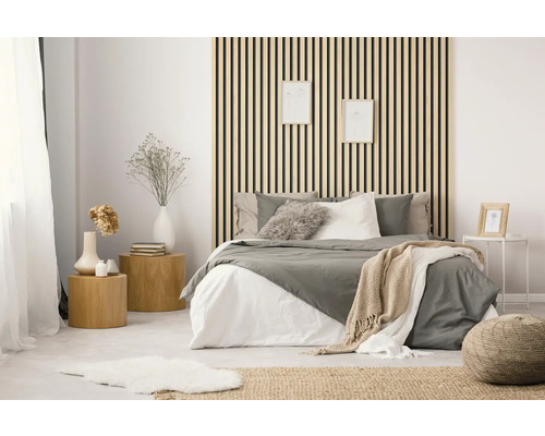 Chambre lumineuse avec lit, tables de chevet et panneaux en bois au mur