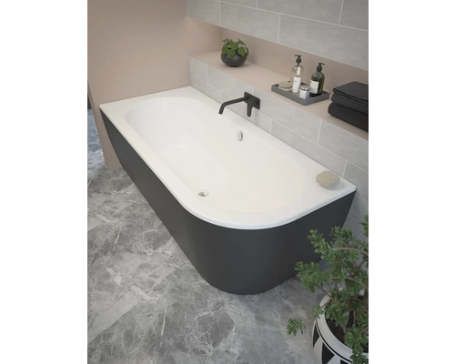 Baignoire îlot dans une salle de bains avec mur carrelé et plante