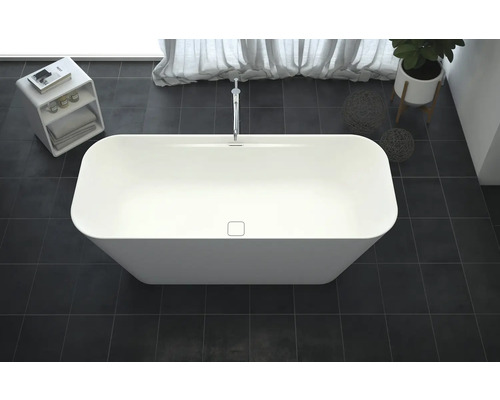 Baignoire îlot dans une salle de bains avec robinetterie, plante et étagère