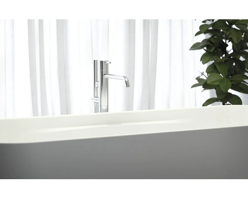 Baignoire îlot avec robinetterie devant une fenêtre