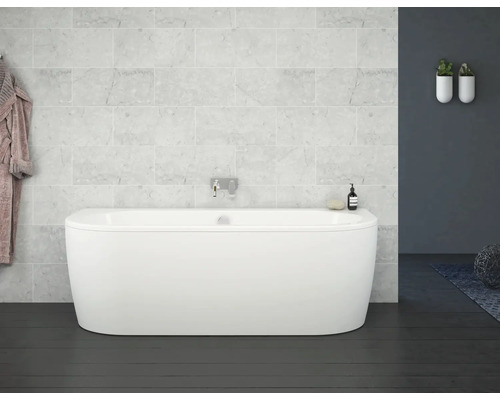 Baignoire îlot dans une salle de bains avec carrelage en marbre clair