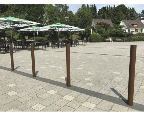 Platz mit Sitzgelegenheiten unter Sonnenschirmen und mehreren Pfosten