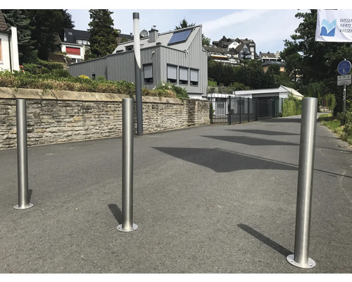 Trois bornes de sécurité en acier inoxydable sur une route