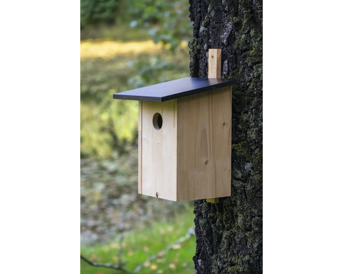 Vogelhaus aus Holz mit schwarzem Dach am Baum