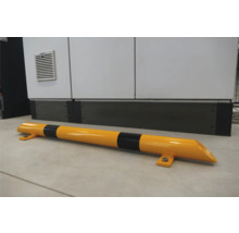 Protection anti-collision jaune et noire devant un mur gris