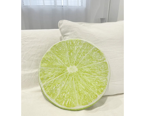 Rundes Kissen mit Limettenmuster auf einem Bett
