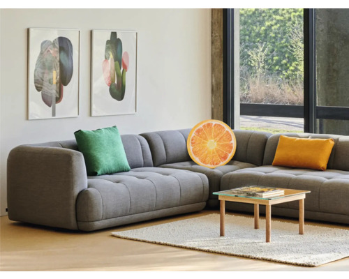 Wohnzimmer mit grauer Eckcouch, Kissen und Couchtisch