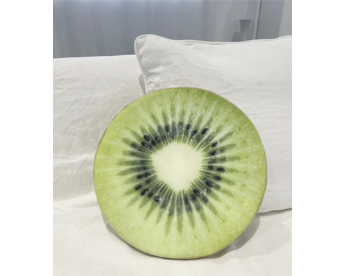 Rundes Kissen mit Kiwi-Design auf einem weißen Kissen