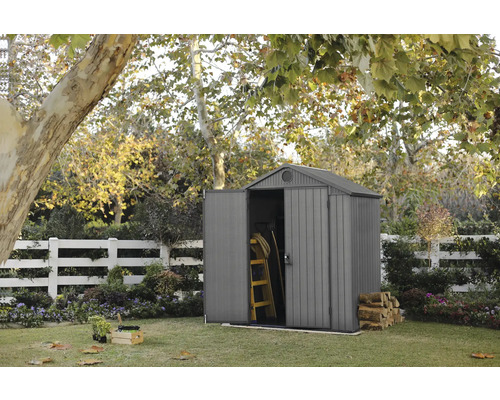 Scène de jardin avec abri de jardin, échelle et bois de chauffage dans le jardin