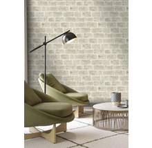 Salon avec papier peint à motifs de briques, fauteuils, lampadaire et table basse