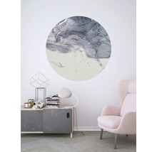 Wohnraum mit runder Wanddekoration mit abstraktem Muster über einem Schrank und neben einem Sessel