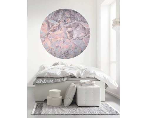 Schlafzimmer mit Bett, Hocker, Teppich und runder Wanddekoration im Kristall-Design für ein helles Ambiente.