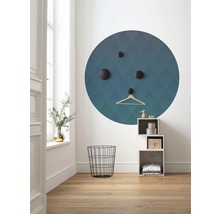 Hell eingerichteter Raum mit einem runden Wandbild, Haken, Kleiderbügel, Drahtkorb und Regal