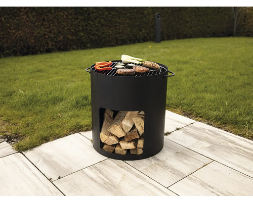Runder Holzkohlegrill aus Metall mit Grillgut und Holz