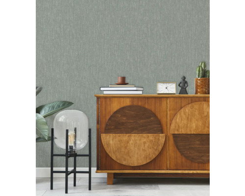 Salon avec papier peint à motifs, buffet et éléments décoratifs.