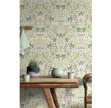 Salon avec papier peint à motifs d''oiseaux et de plantes derrière une table en bois
