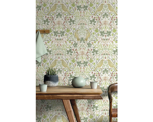 Salon avec papier peint à motifs d''oiseaux et de plantes derrière une table en bois