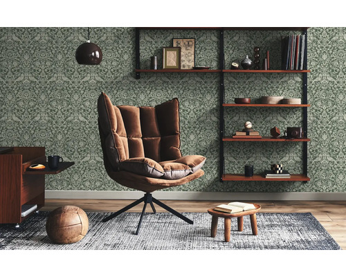 Wohnzimmer mit Sessel, Regal und gemusterter Tapete