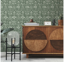 Intérieur avec papier peint à motifs verts et un meuble en bois