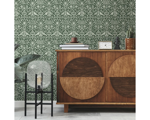 Innenraum mit grüner gemusterter Tapete und einem Holzschrank