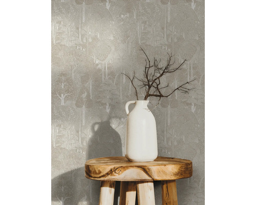 Papier peint à motif d''arbres sur un mur, avec un vase blanc contenant des branches sur un tabouret en bois