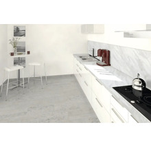 Cuisine lumineuse avec armoires blanches, évier, plaque de cuisson et table à manger