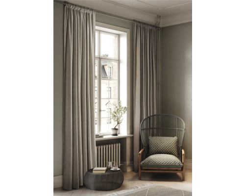 Wohnzimmer mit Vorhängen, Sessel und Tisch