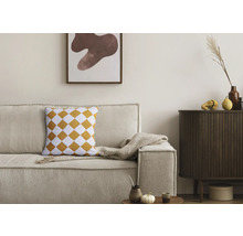 Wohnzimmer mit Kordsofa, Rautenmusterkissen und Holzkommode